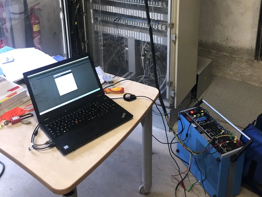 Essais de relais de protection sur site — valise d'injection raccordée à une armoire de contrôle-commande